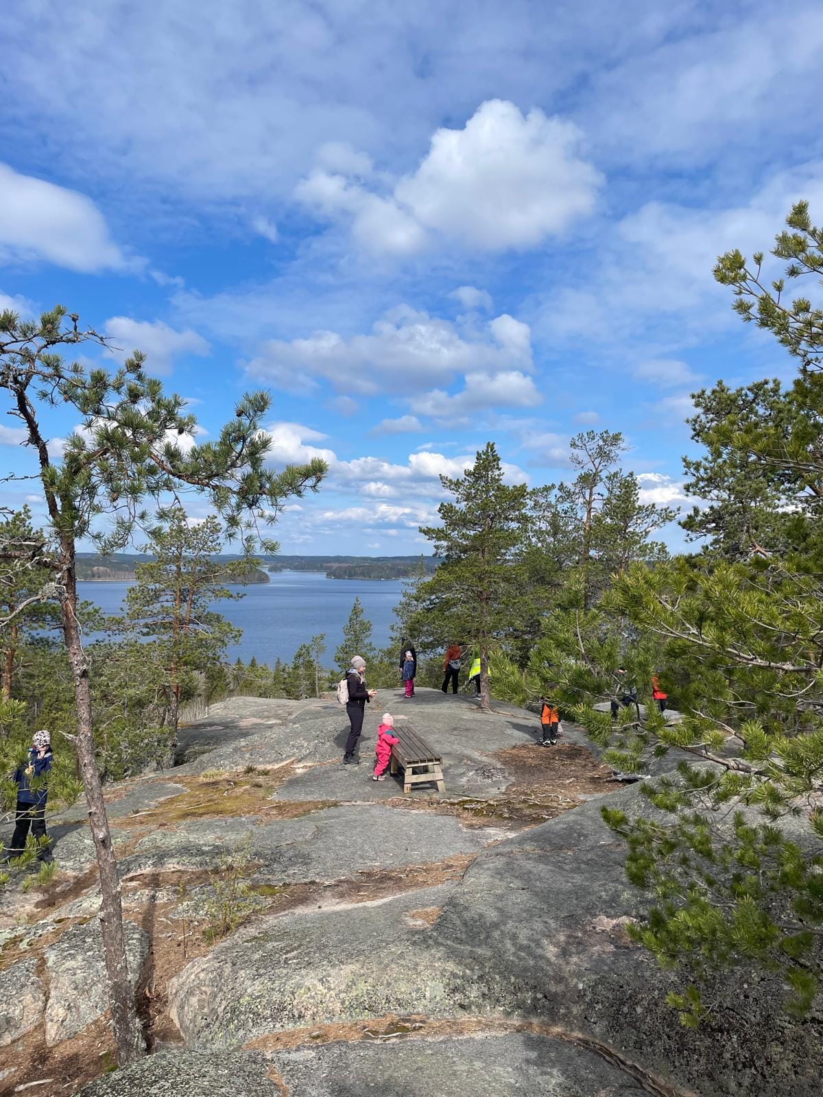 Perhepartiolaisia leikkimässä aurinkoisella kalliolla.